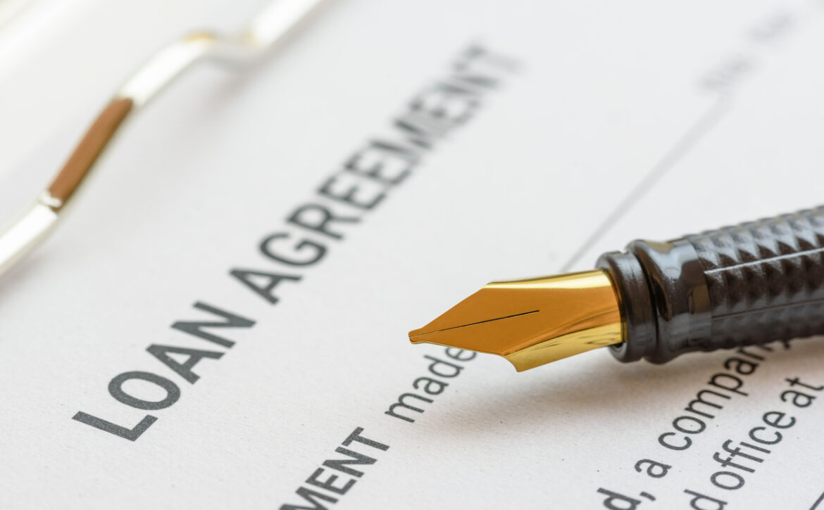 Business loan agreement or legal document concept : Fountain pen on a loan agreement paper form. Loan agreement is a contract between a borrower and a lender, a compilation of various mutual promises.