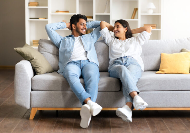 Cheerful Indian couple enjoying a moment on a couch in a cozy living room