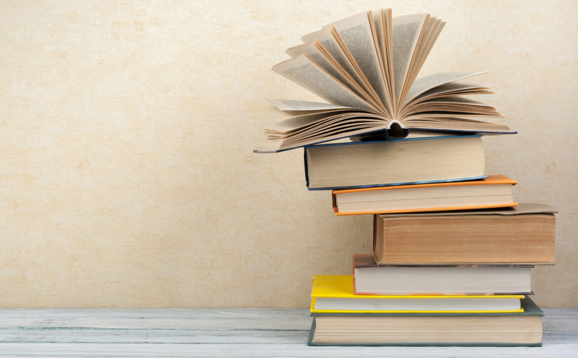 Stack of colorful books. Education background. Back to school. Book, hardback colorful books on wooden table. Education business concept. Copy space for text.