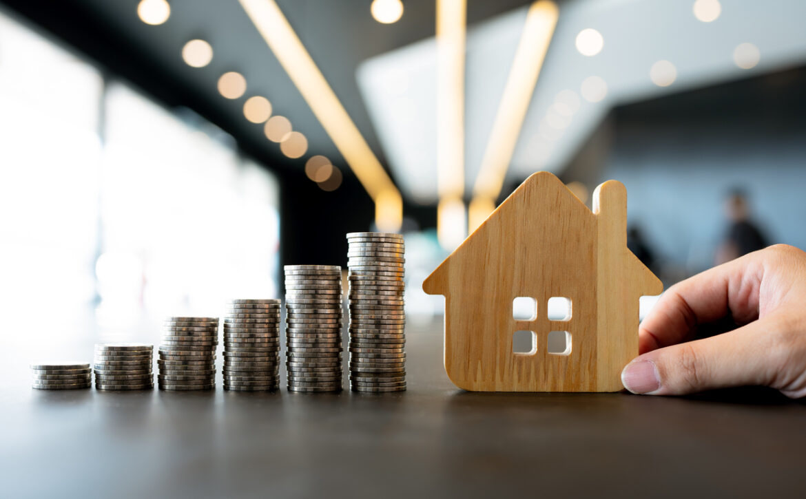 Wood house and row of coin money on wood table and , selective focus, Planning to buy property. Choose what's the best. A symbol for construction ,ecology, loan concepts.
