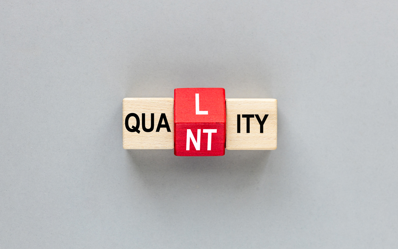 QUALITY and QUANTITY concept. letters on wooden blocks changes the word quality to quantity. Business concept. beautiful gray background. flat lay, copy space