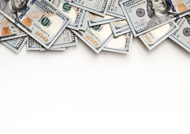 US paper currency with close-up details of one hundred dollar bills. Top view layout with negative space for financial concepts. Banknotes positioned at the top, leaving room for text.