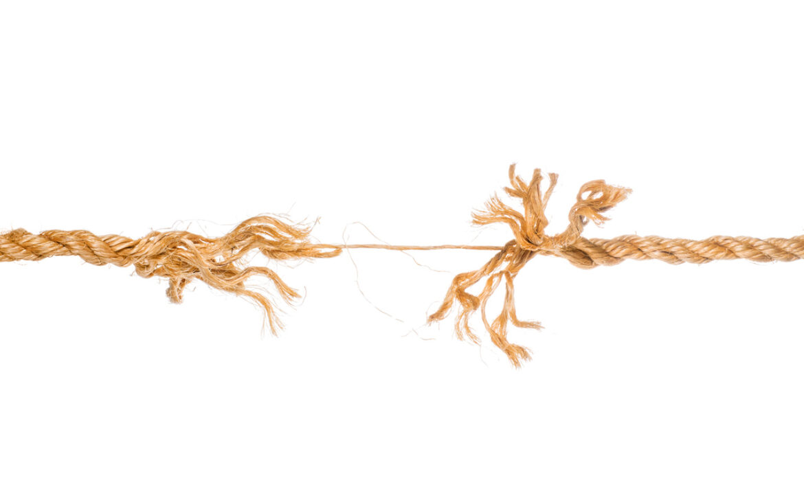 Long frayed rope near to break isolated