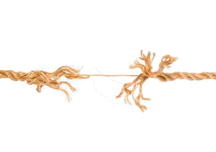 Long frayed rope near to break isolated
