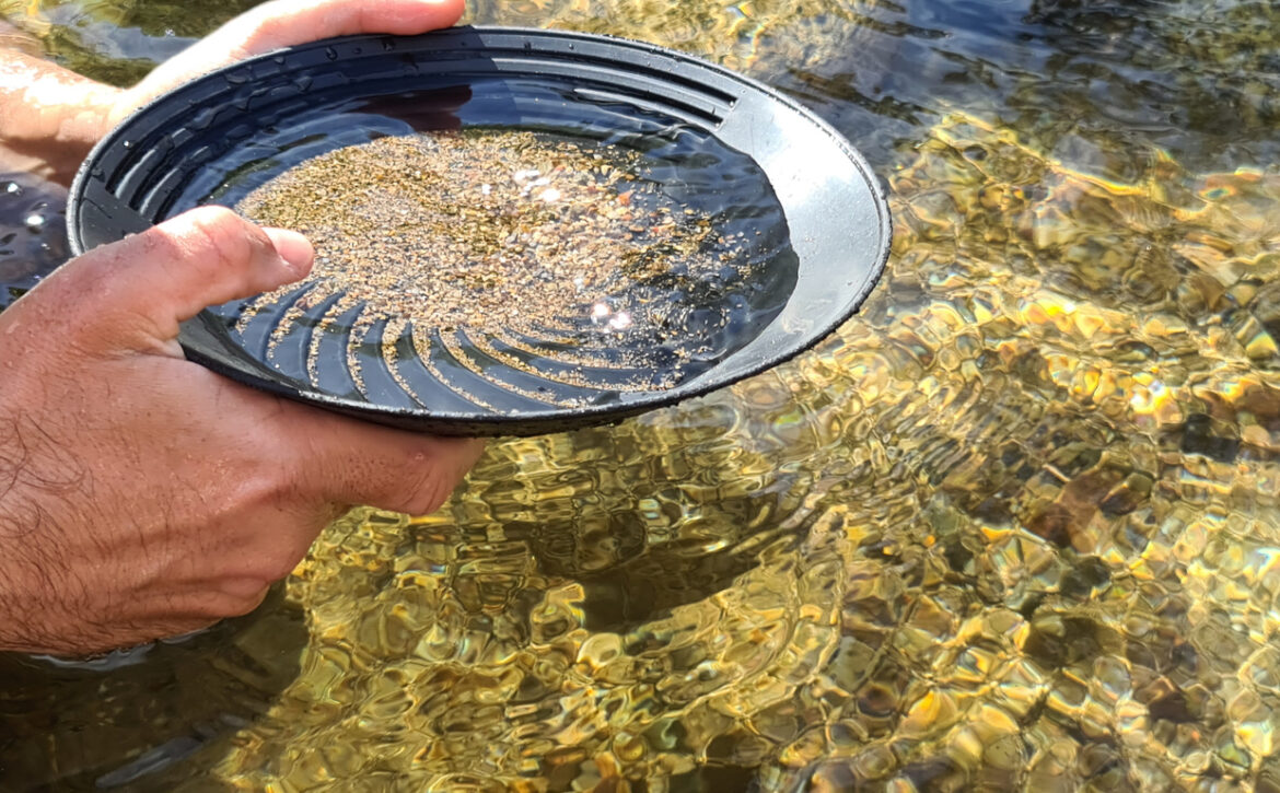 Close-up of a man's hands holding a gold panning prospecting pan