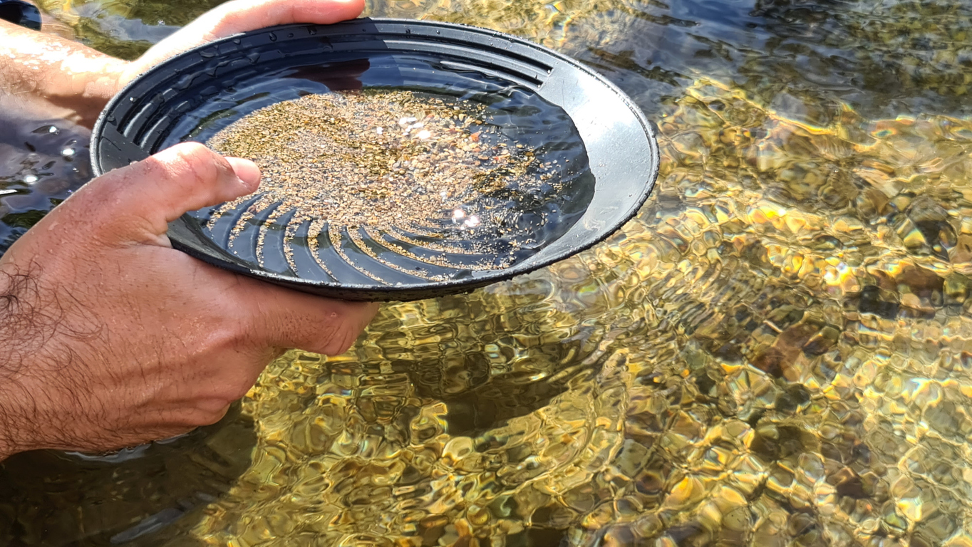 Close-up of a man's hands holding a gold panning prospecting pan