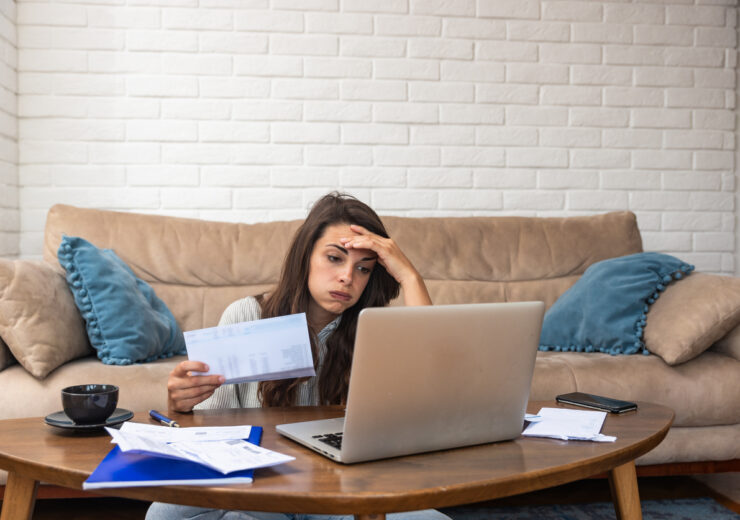 Young stressed woman having issue with utility bills expense, sitting at home trying to calculate and see bad finance bank report, searching for mistake. College student girl with money problem.