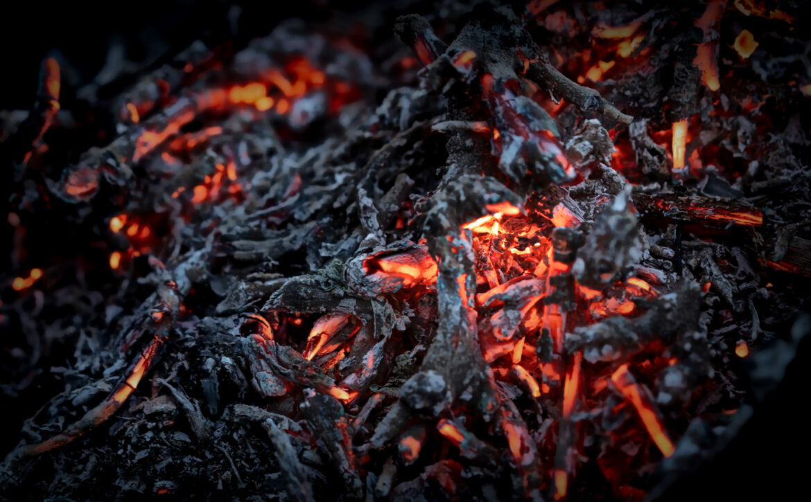 Glowing embers in a darkened space create a mesmerizing and warm ambiance during a quiet evening
