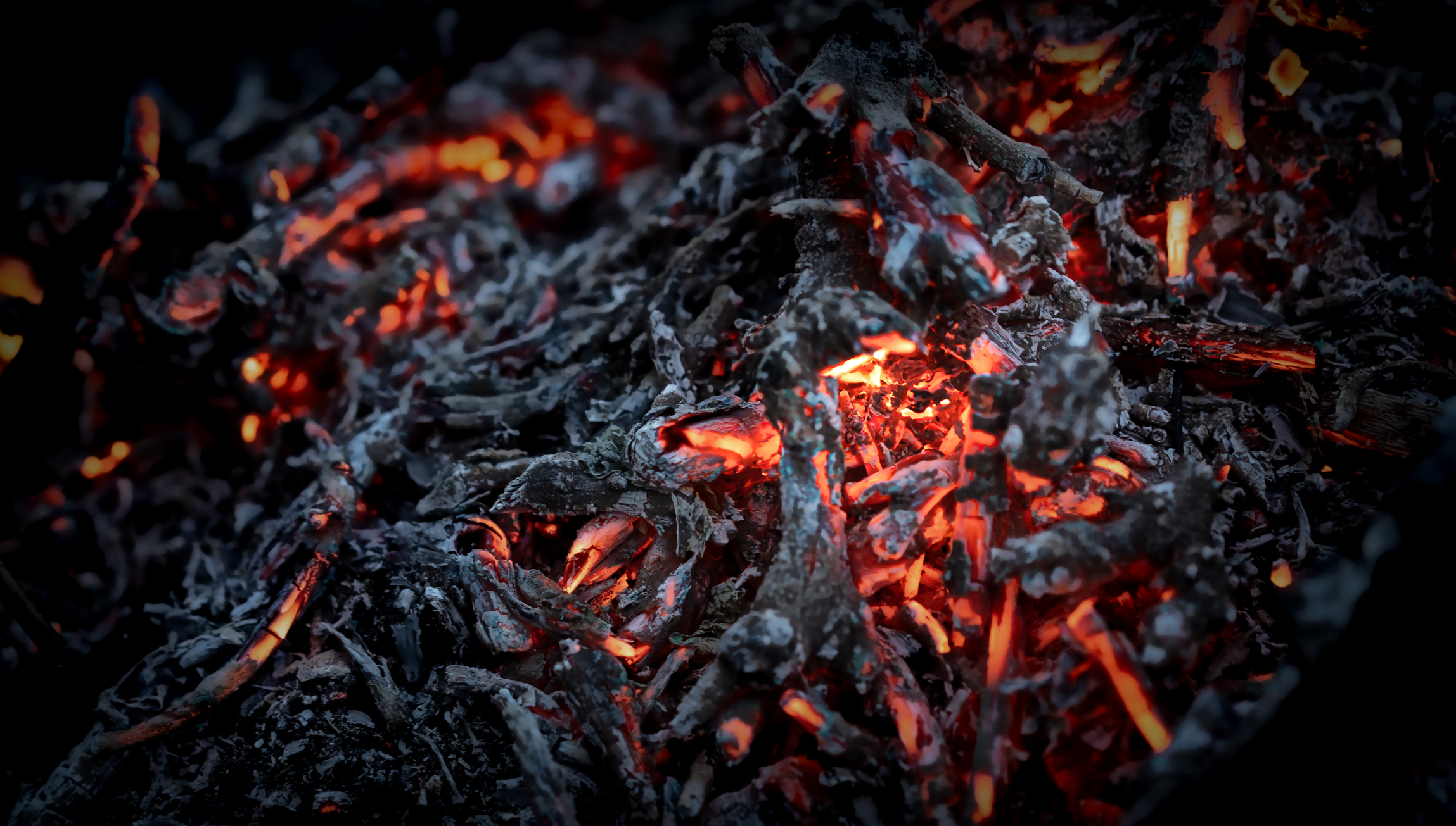 Glowing embers in a darkened space create a mesmerizing and warm ambiance during a quiet evening