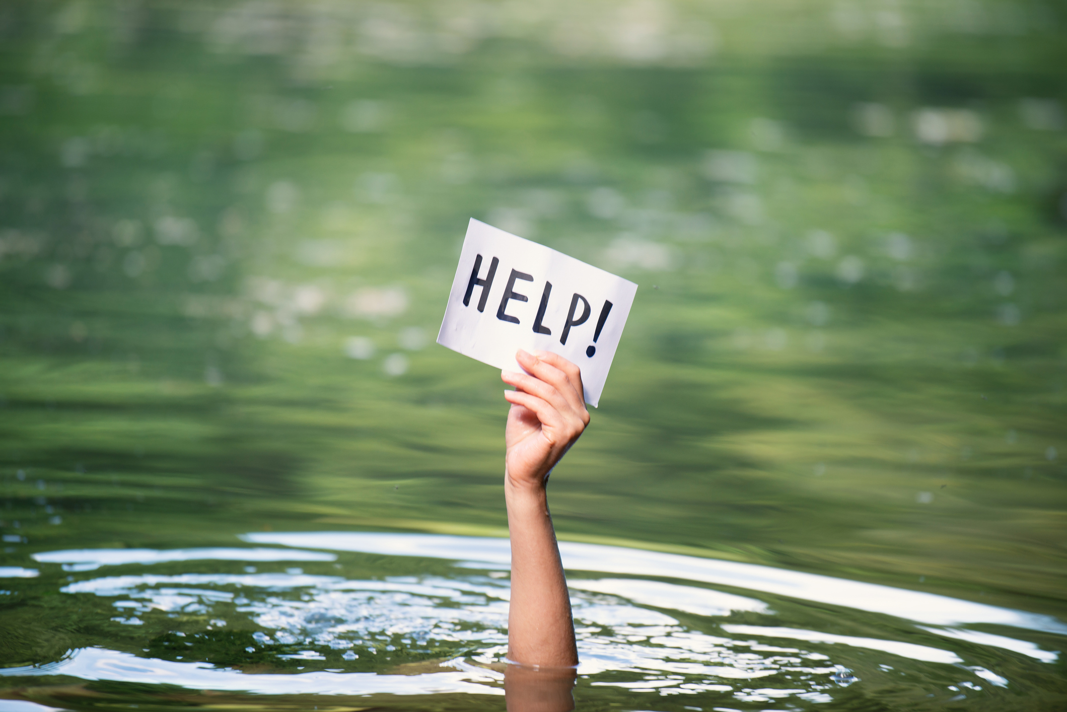 Drowning victim, hand with help sign, danger of swimming in lake or river, struggle to survive, failure and rescue in waters