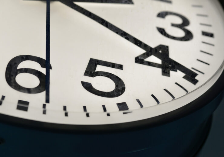 A close-up view of a vintage analog clock showing the time with bold black numbers