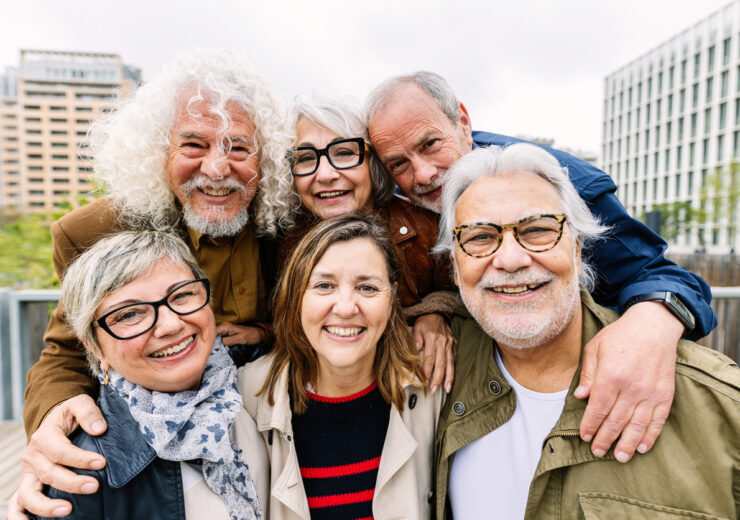 Portrait of happy diverse senior friends standing together at city