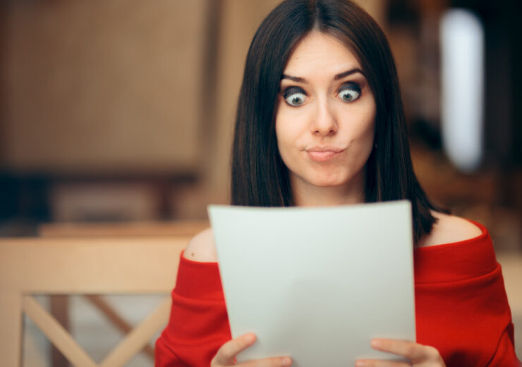Surprised Woman Reading Legal Documents in a Restaurant