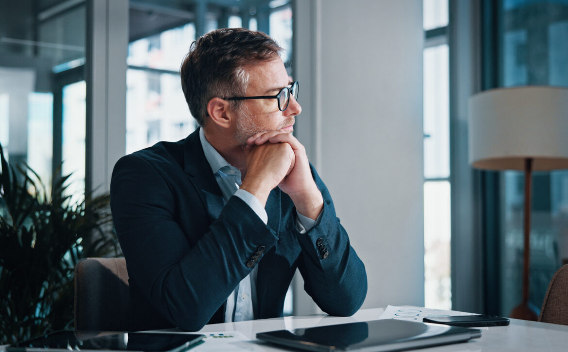 Business, thinking and man in office, solution and decision for career growth, doubt and problem solving. Person, employee and consultant in workplace, laptop and planning with choice and options