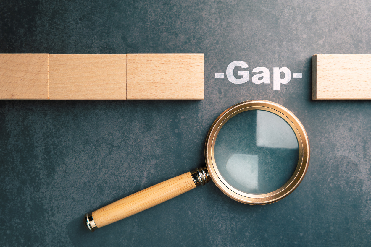 Gap analysis concept with magnifying glass examining missing block