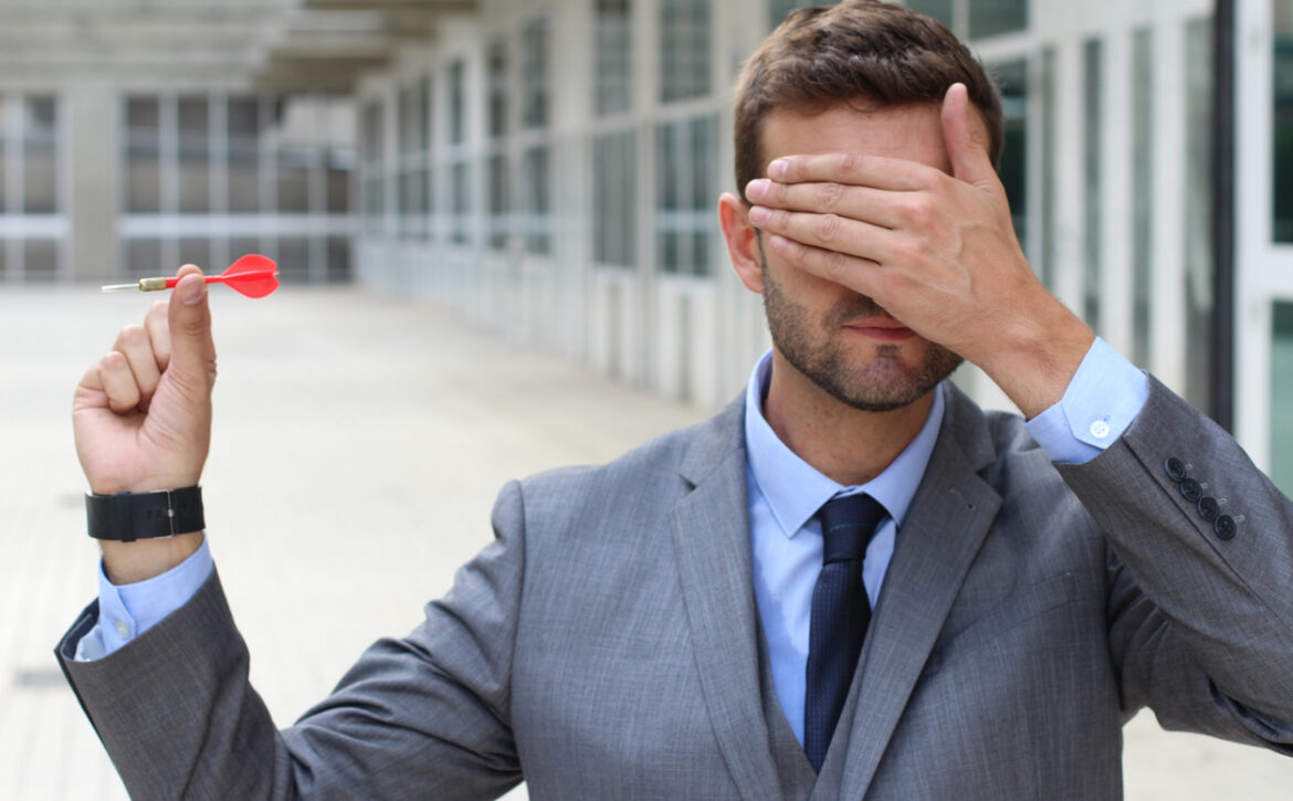 Blind businessman holding a dart