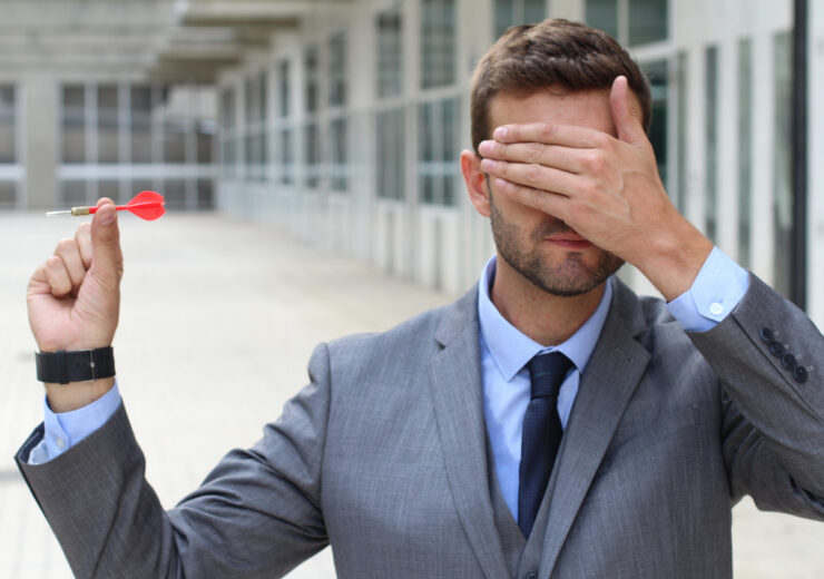 Blind businessman holding a dart