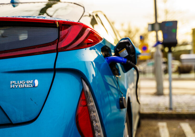 Electric plug in hybrid car parked on street parking lot for charging
