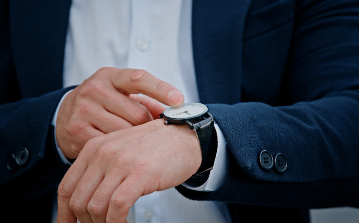 Cropped view closeup male hand with wristwatch clock Asian middle-aged businessman manager man male boss company CEO entrepreneur employer check time lateness waiting for meeting taxi in city outdoors