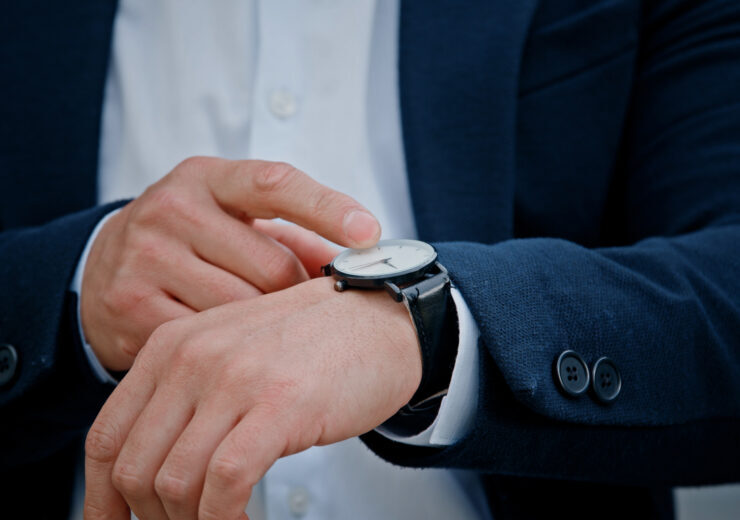 Cropped view closeup male hand with wristwatch clock Asian middle-aged businessman manager man male boss company CEO entrepreneur employer check time lateness waiting for meeting taxi in city outdoors