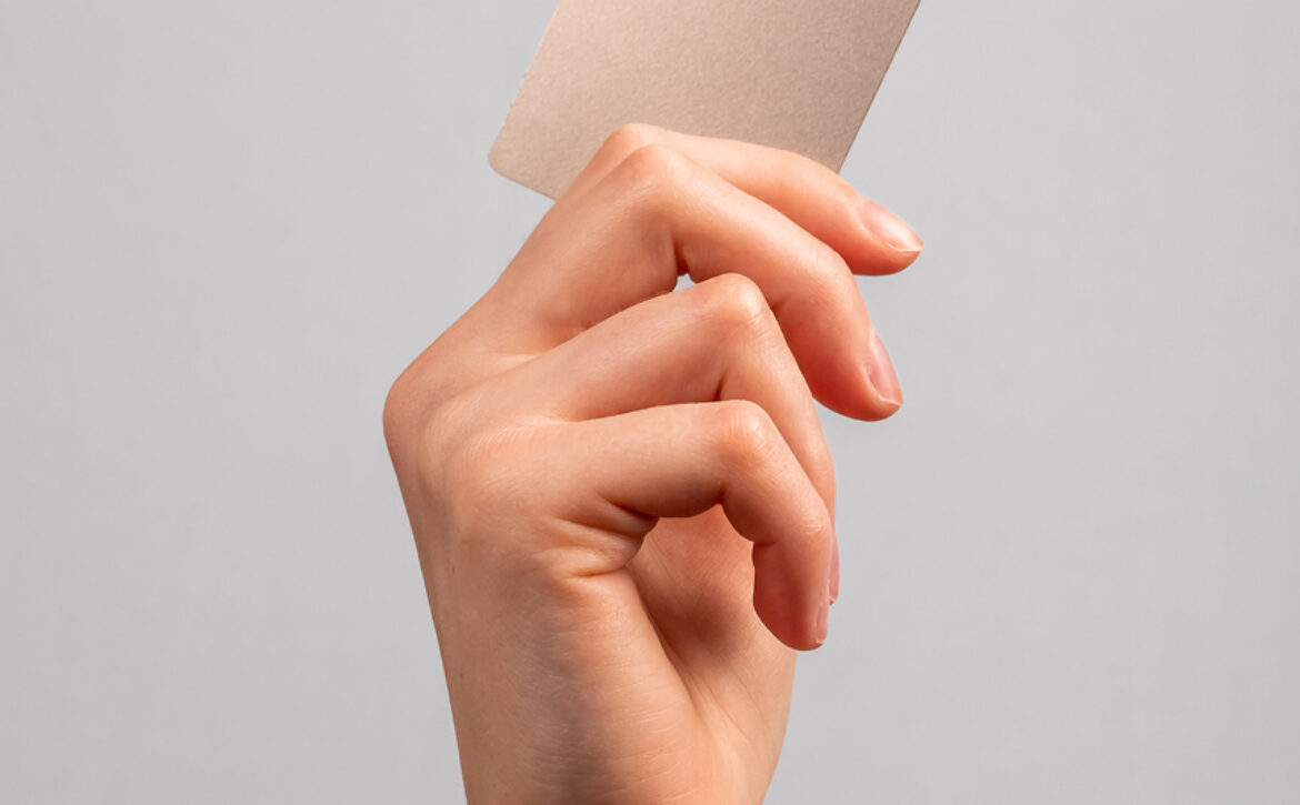 Hand holding credit card mockup with chip. Buying at stores, making transactions at terminals. Secure payments